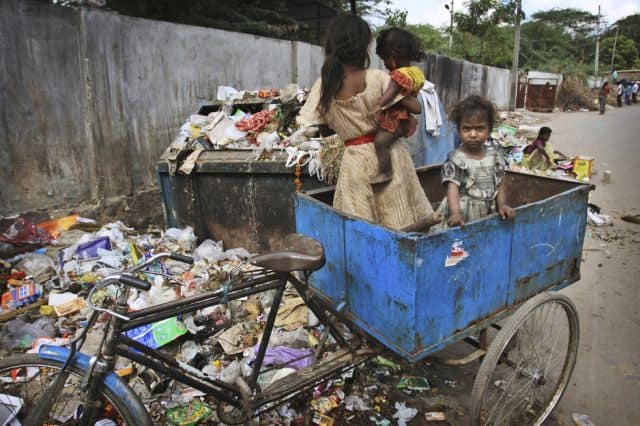 kids with their mother on a bike at a trash heap